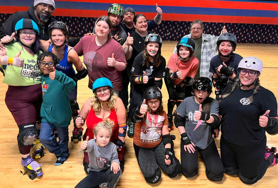 group of derby players of all ages with thumbs up
